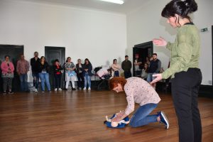 Formanda exemplifica manobra de Suporte Básico de Vida Pediátrico com orientações da formadora