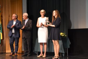 Prof.ª Dr.ª Raquel Duarte com familiar de vítima do acidente a mostrar medalha